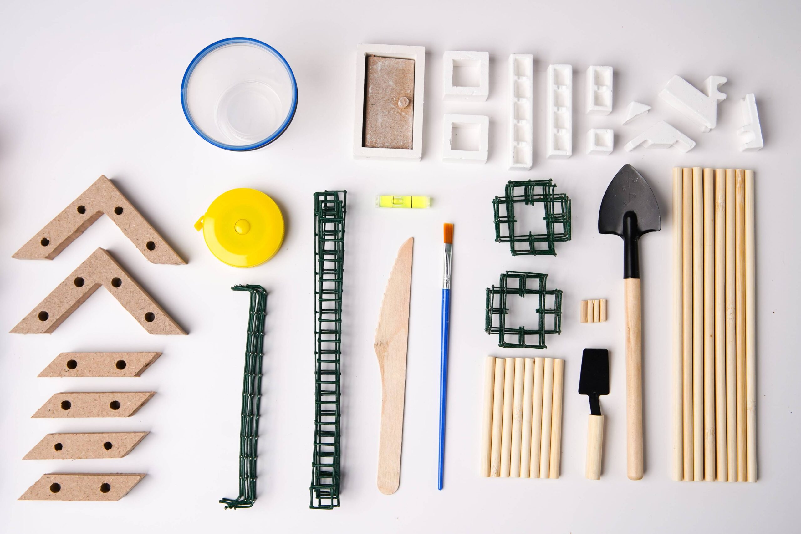 Plastic and wooden construction tools and materials for model building or DIY projects.